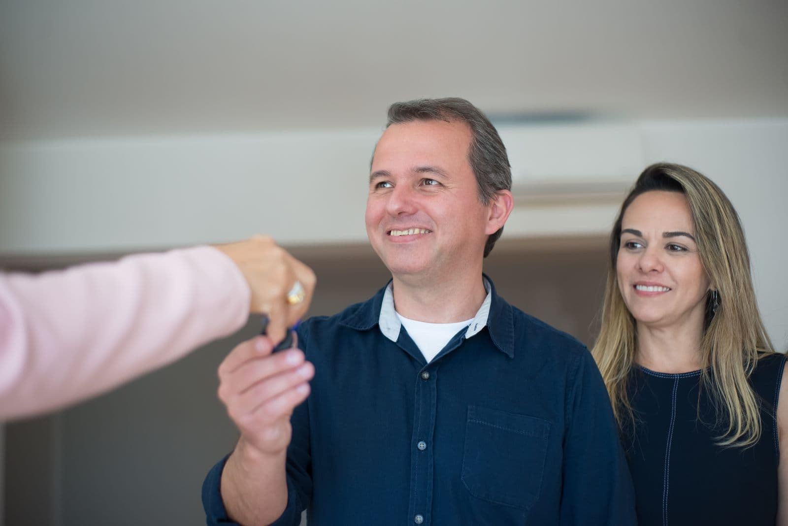 Un couple souriant reçoit les clés de son nouveau logement