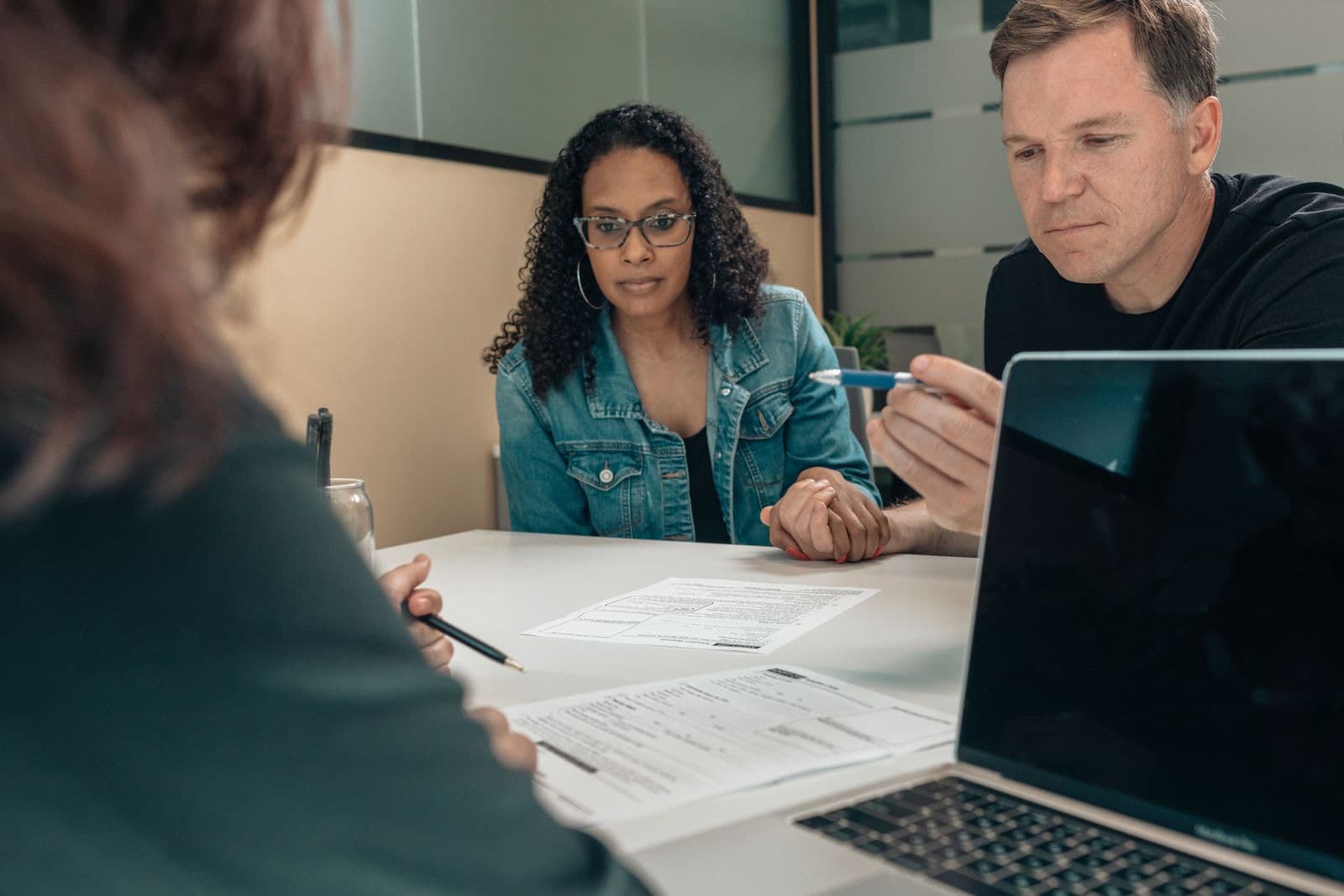 Un couple examine des documents de financement avec un conseiller